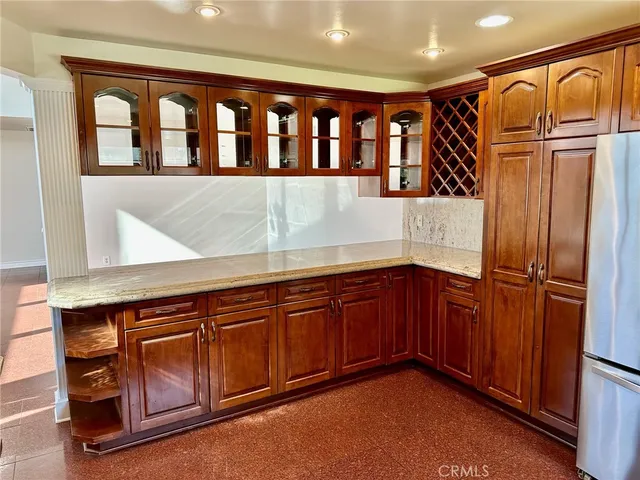 a kitchen with stainless steel appliances granite countertop a refrigerator and cabinets