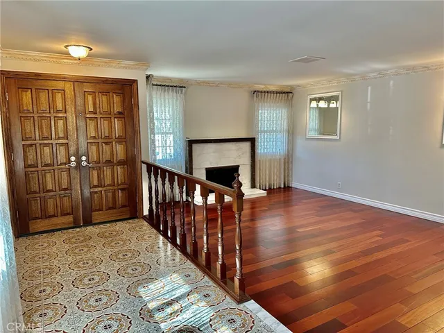 a view of a livingroom with wooden floor & staircase