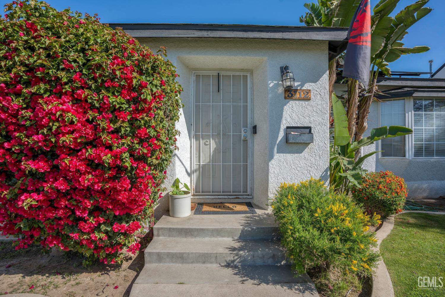 Undisclosed Address Bakersfield, CA 93304 - Photo 5 of 31 a front view of a house with a flower garden
