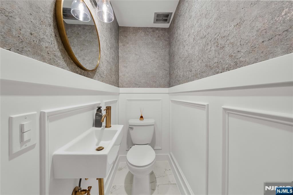 609 Wyndham Road Teaneck, NJ 07666 - Photo 1 of 26 a bathroom with a toilet and a mirror