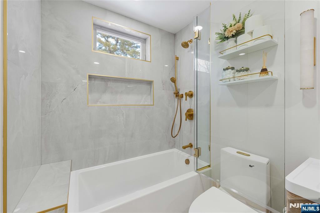 609 Wyndham Road Teaneck, NJ 07666 - Photo 11 of 26 a bath room with a toilet a bath tub and a shower