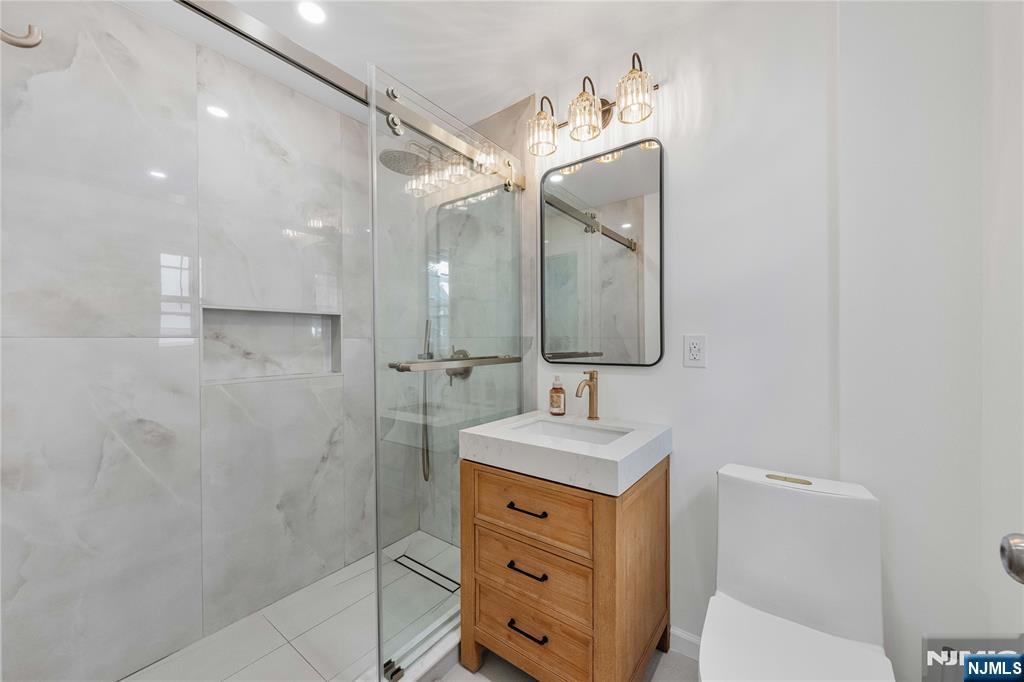 609 Wyndham Road Teaneck, NJ 07666 - Photo 14 of 26 a bathroom with a sink a toilet and shower