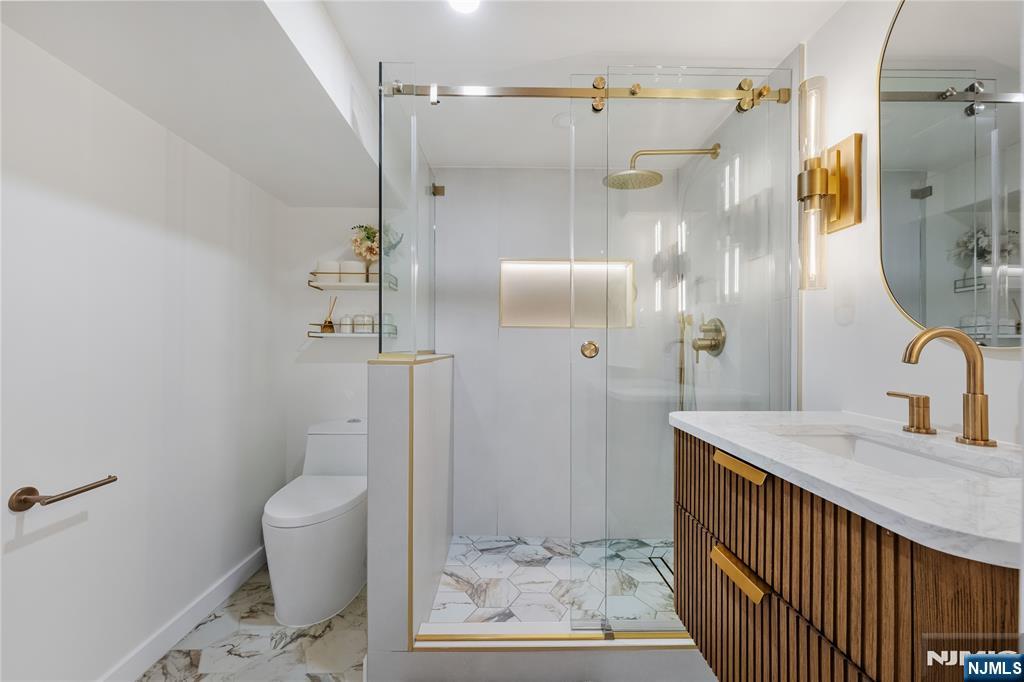 609 Wyndham Road Teaneck, NJ 07666 - Photo 22 of 26 a bathroom with a granite countertop sink a toilet and shower
