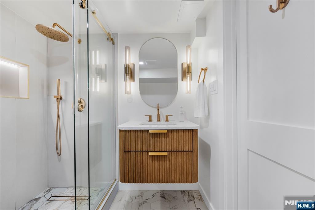 609 Wyndham Road Teaneck, NJ 07666 - Photo 23 of 26 a room with a mirror and a sink