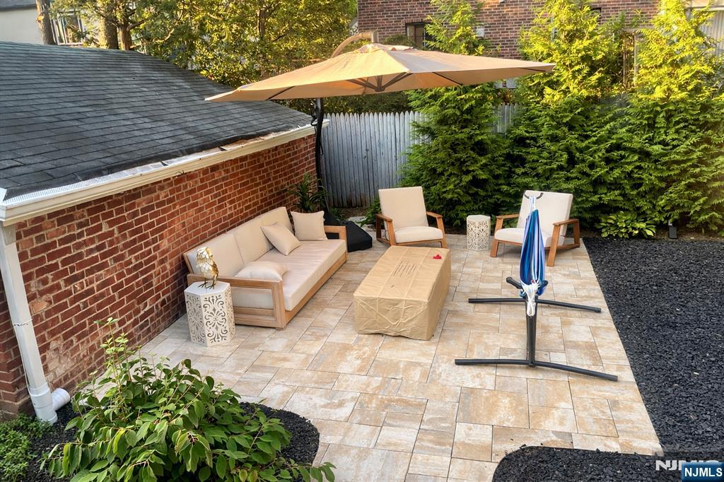 609 Wyndham Road Teaneck, NJ 07666 - Photo 25 of 26 a view of backyard with table and chairs under an umbrella