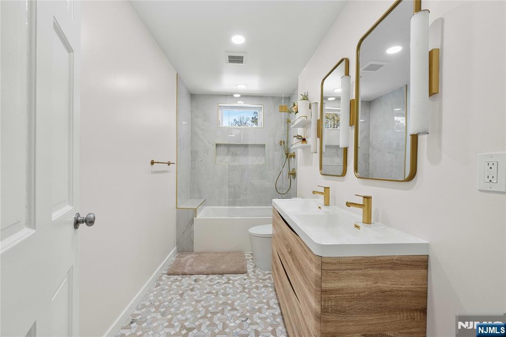 609 Wyndham Road Teaneck, NJ 07666 - Photo 10 of 26 a bathroom with a sink a toilet and shower