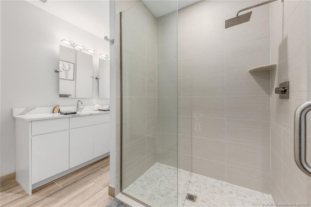 41 Southwest Seminole Street, Unit 410 Stuart, FL 34994 - Photo 20 of 54 a bathroom with a shower sink and mirror