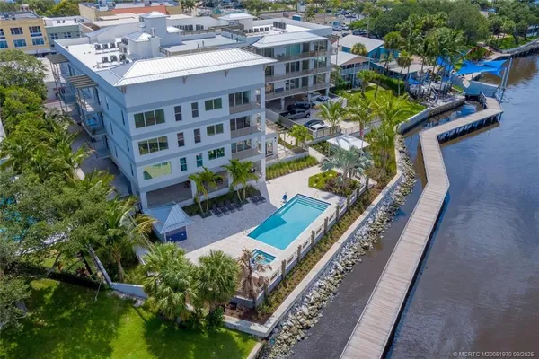 a view of a swimming pool with a yard and potted plants