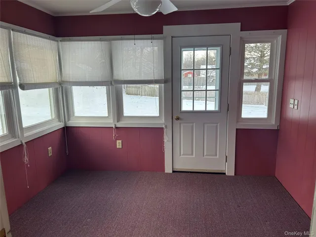 an empty room with windows and cabinet
