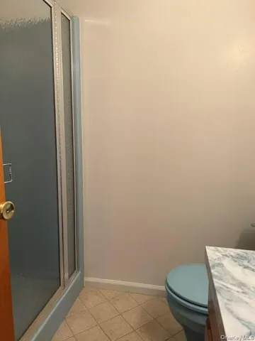 a white toilet sitting next to a shower