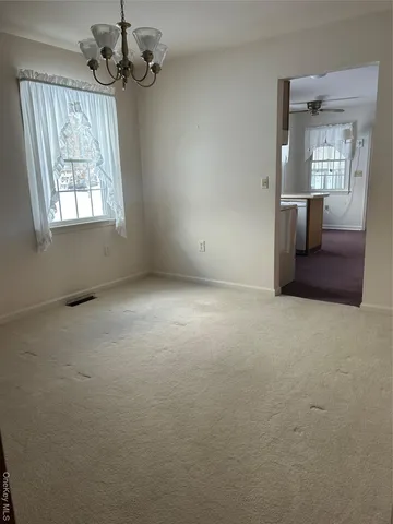 en empty room with windows and ceiling fan