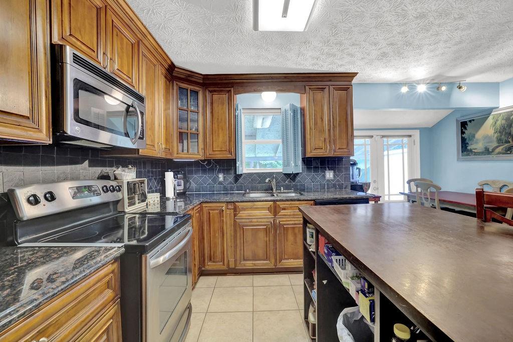 1555 Rock Springs Road Buford, GA 30519 - Photo 10 of 27 a kitchen with stainless steel appliances granite countertop a stove a sink and a microwave