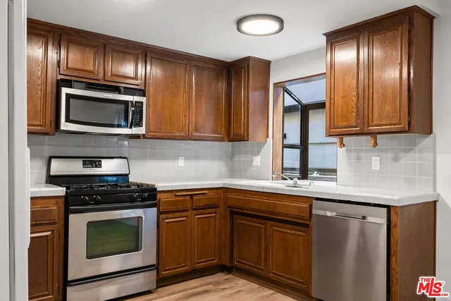 a kitchen with granite countertop cabinets stainless steel appliances and wooden floor