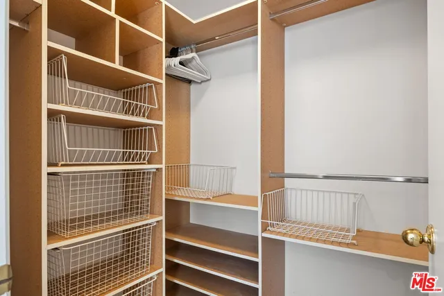 a view of walk in closet with empty racks