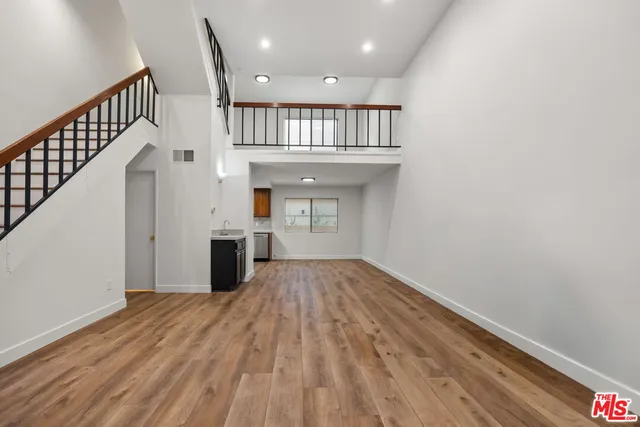 a view of a hallway with wooden floor and staircase