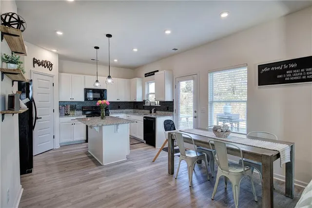 a kitchen with white cabinets and refrigerator