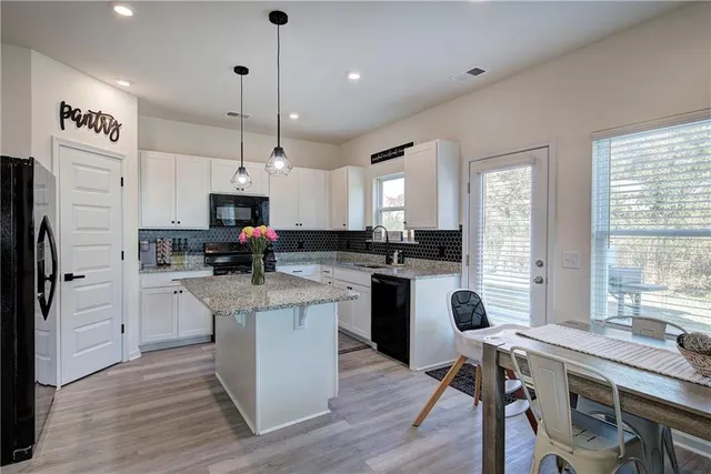 a kitchen with white cabinets and appliances