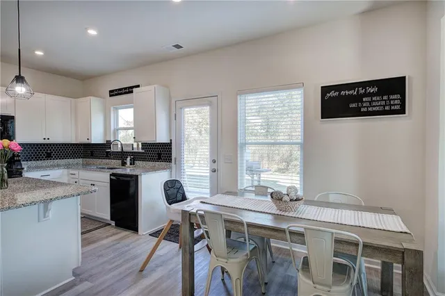 a kitchen with a table chairs sink and cabinets