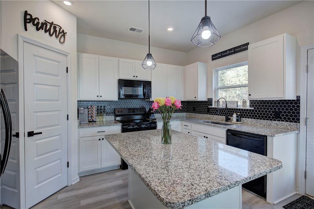 10 Eagle Drive Northwest Cartersville, GA 30121 - Photo 15 of 41 a kitchen with granite countertop a sink a counter space appliances and cabinets