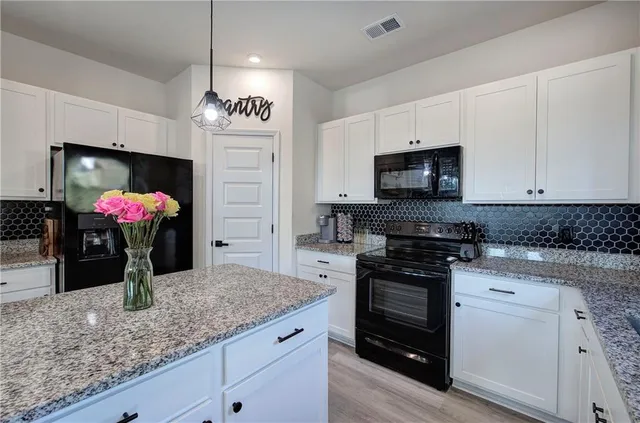 a kitchen with kitchen island granite countertop stainless steel appliances a sink stove and microwave