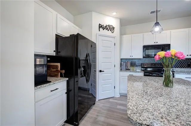 a kitchen with stainless steel appliances kitchen island sink refrigerator and microwave