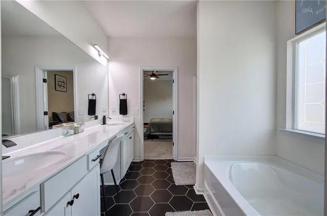 a spacious bathroom with a bathtub sink and mirror