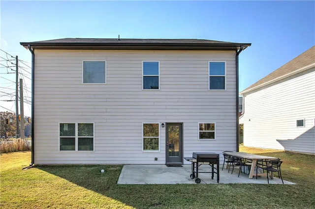 a view of a house with backyard and a patio
