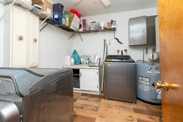 a kitchen with stainless steel appliances granite countertop a sink dishwasher stove and refrigerator with wooden floor