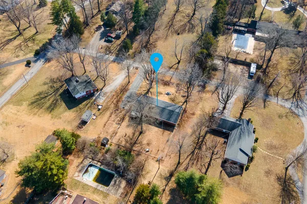 an aerial view of a house with a yard and trees
