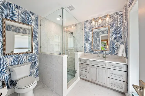 a bathroom with a sink a toilet a mirror and shower