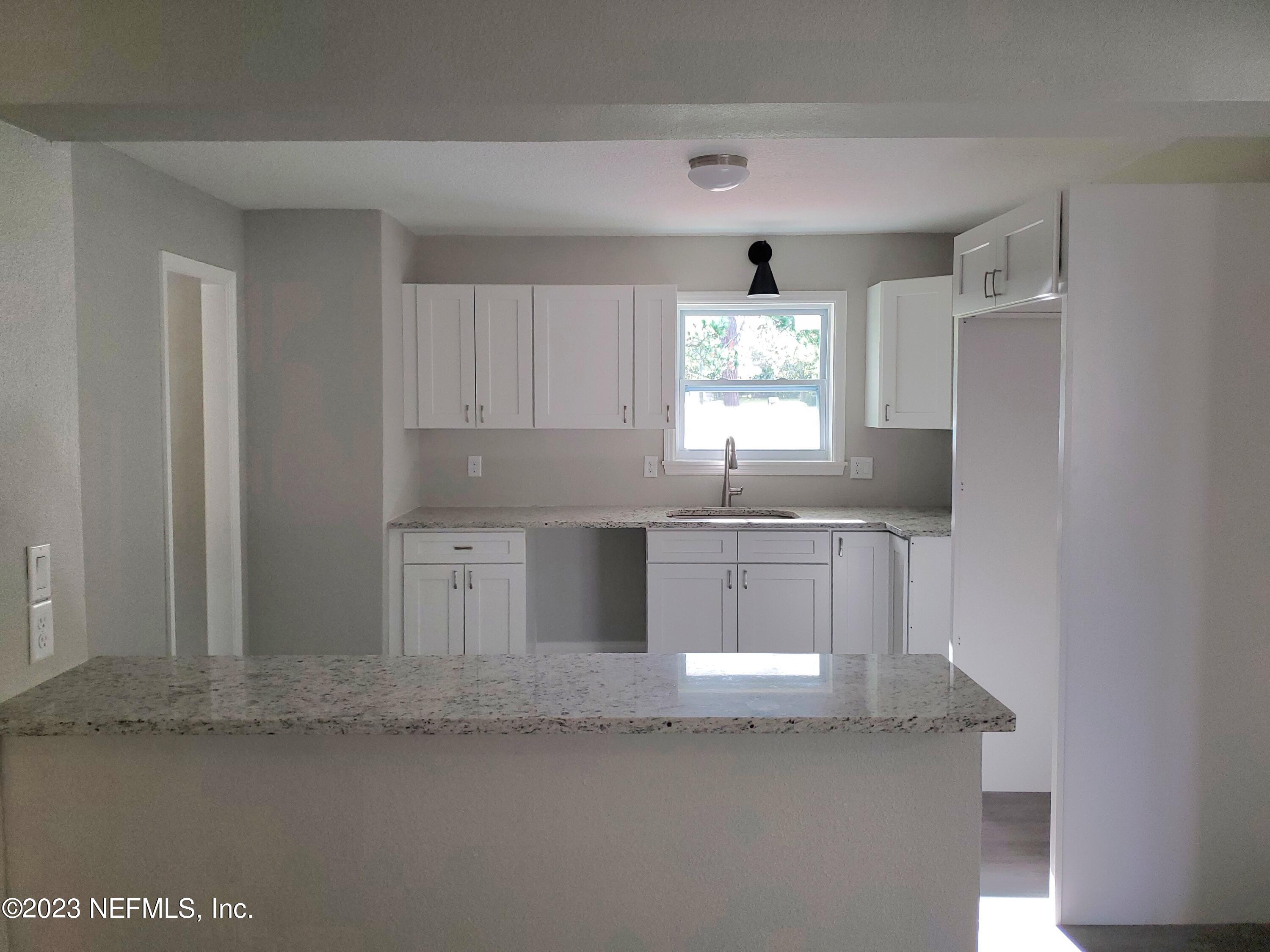 2305 Brest Road Jacksonville, FL 32216 - Photo 2 of 32 a kitchen with granite countertop a sink window and cabinets