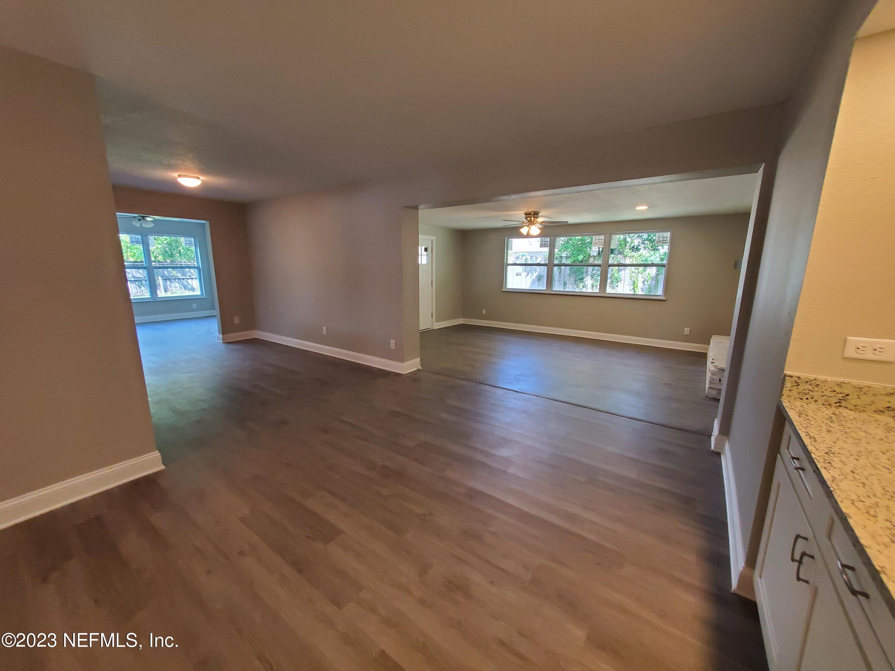 2305 Brest Road Jacksonville, FL 32216 - Photo 7 of 32 an empty room with wooden floor and windows
