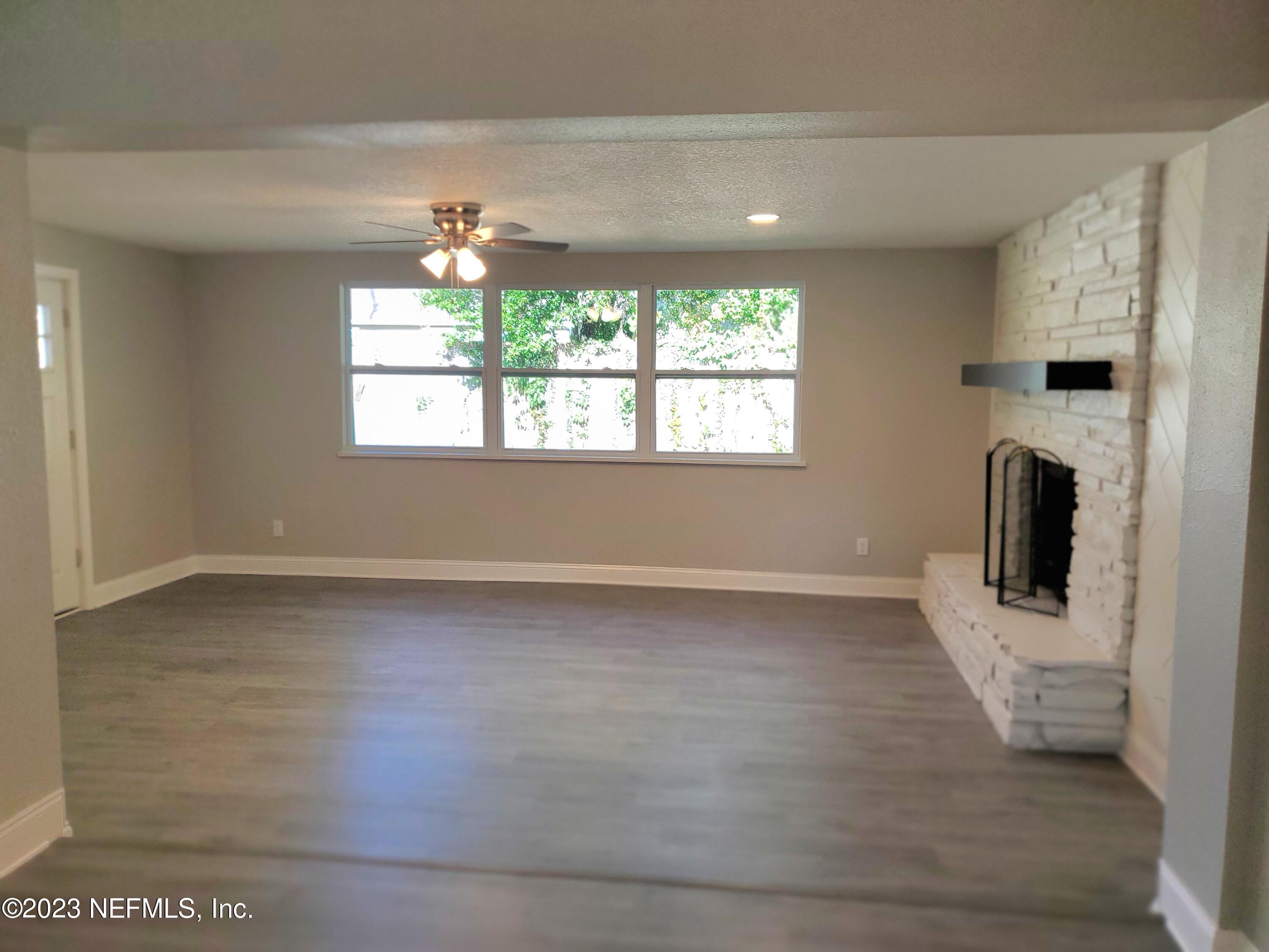2305 Brest Road Jacksonville, FL 32216 - Photo 8 of 32 an empty room with wooden floor and a window