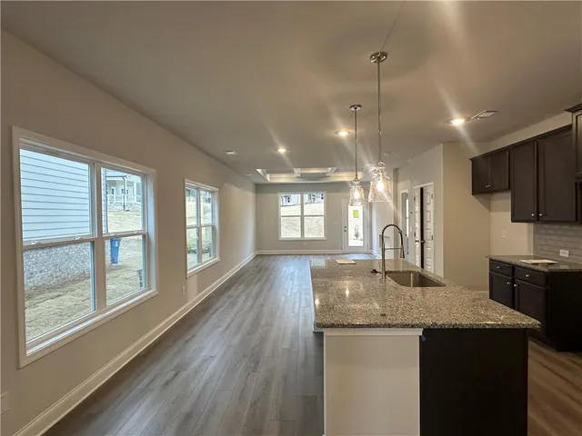 a kitchen with kitchen island granite countertop wooden floor and center island