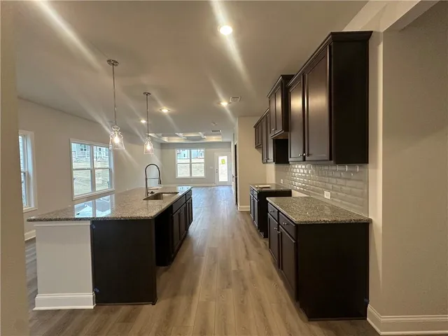 a kitchen with granite countertop counter top space a sink stainless steel appliances and windows