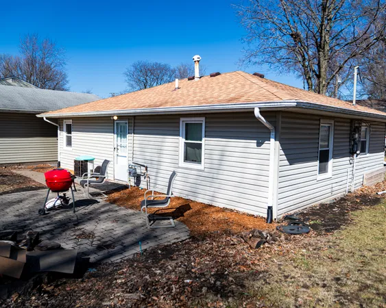 a backyard of a house with barbeque oven table and chairs