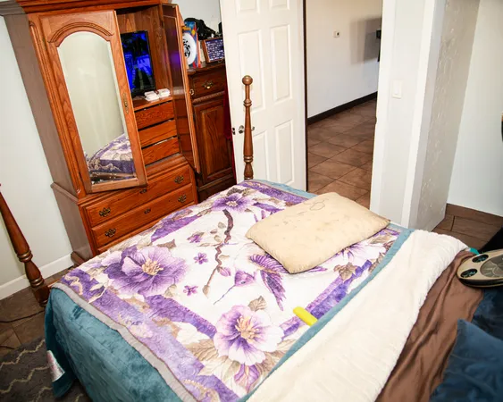 a bedroom with a bed and a flat screen tv on a dresser