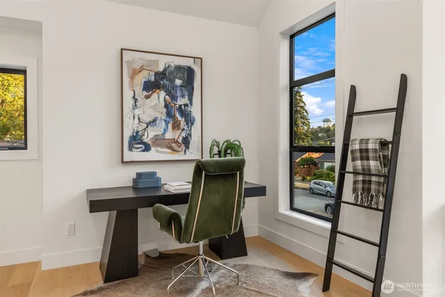 a view of a workspace with furniture and a window