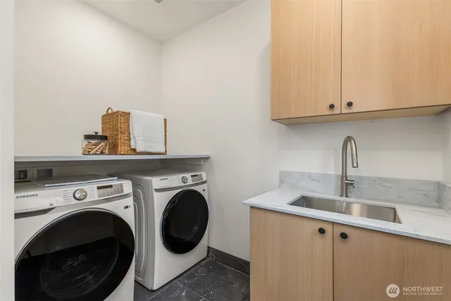 a utility room with sink dryer and washer