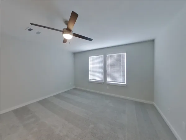 an empty room with a window and ceiling fan