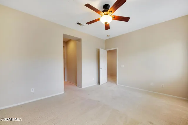 an empty room with a ceiling fan and a window