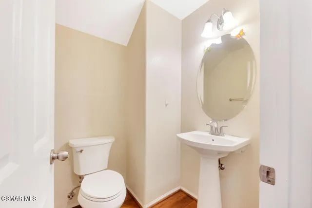 a bathroom with a sink mirror and toilet