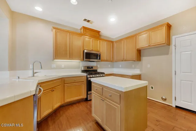 a kitchen with a sink stove top oven and refrigerator