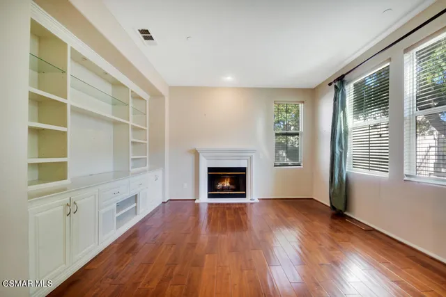 a view of an empty room with a fireplace and a window