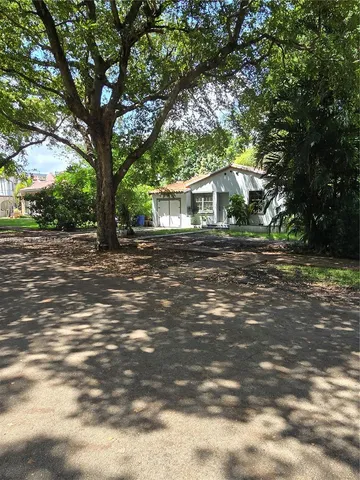 a view of a house with a tree in front of it