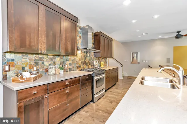 a kitchen with stainless steel appliances granite countertop a sink a stove and cabinets
