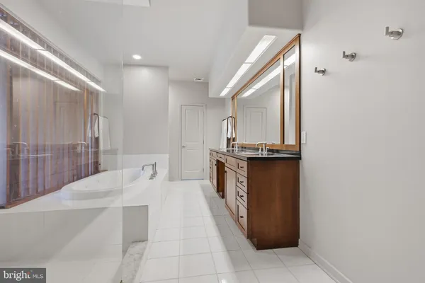 a bathroom with a granite countertop sink a mirror and shower