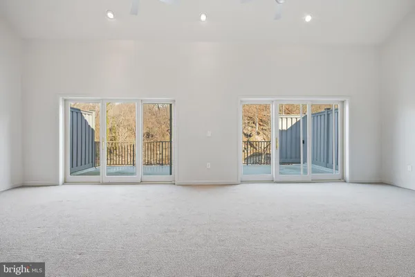 an empty room with large window and doors