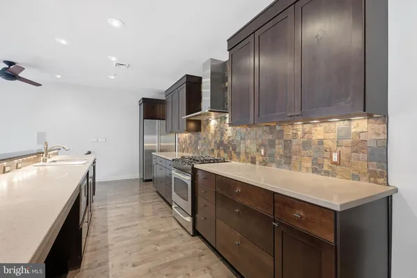 a kitchen with a sink cabinets stainless steel appliances and a window