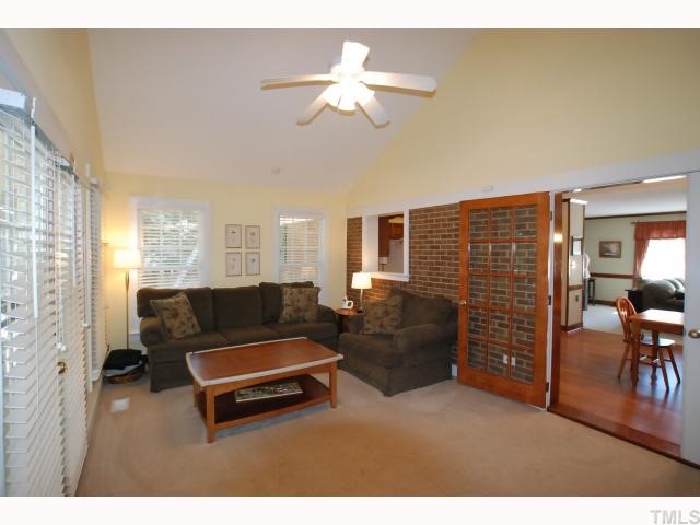 7516 Deer Track Drive Raleigh, NC 27613 - Photo 3 of 11 Bright Family Room with Cathedral Ceiling, Lighted Ceiling Fan, Plantation Blinds, Pass Thru to Kitchen & French Doors to the Dining Area & Screened Porch.